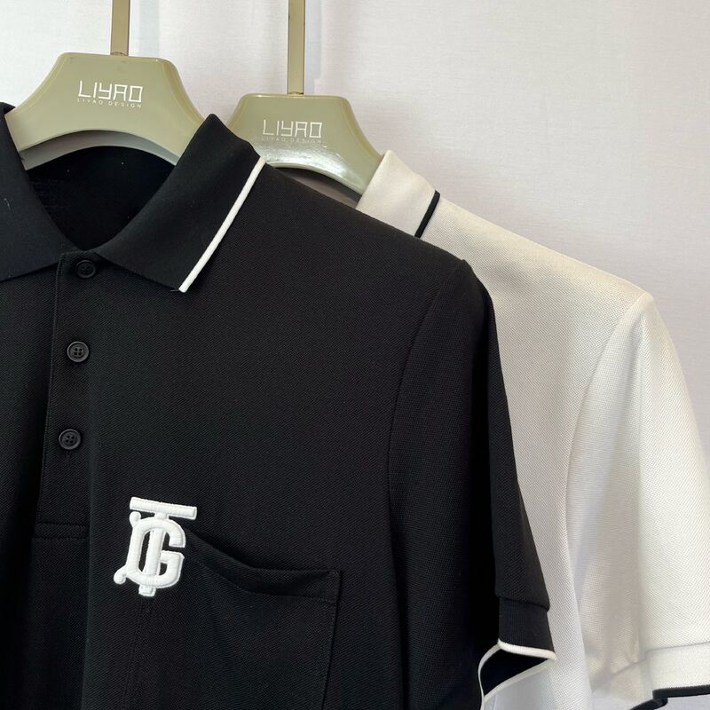 قميص بولو رجالي بشعار مطرز | أسود مع جيب صدري بأطراف بيضاء وتصميم عصري بحروف أولى قميص بولو رجالي من البيكيه
